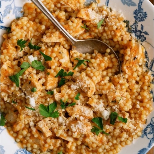 Top view of a bowl of Pastina Soup with a spoon.