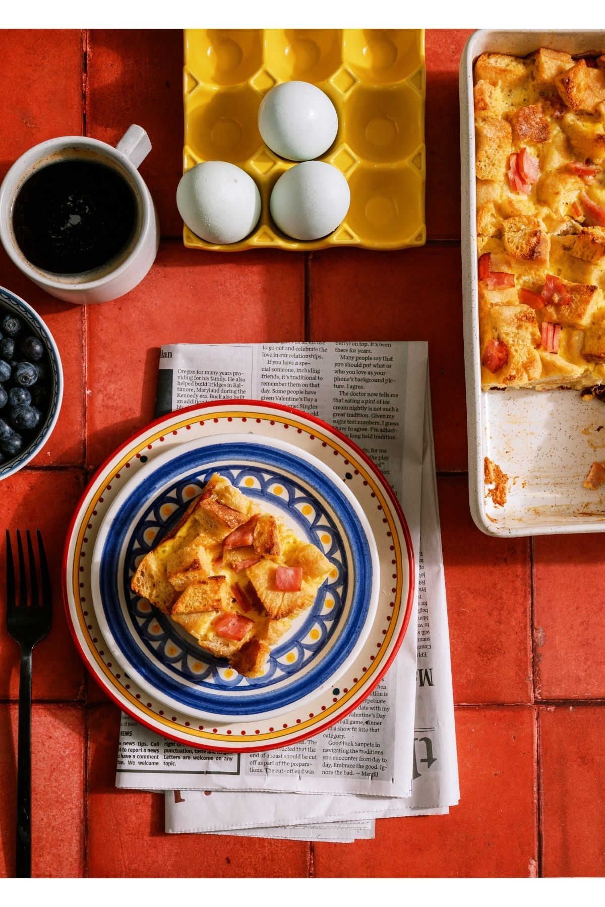 A slice of Eggs Benedict Casserole on a plate with the remaining casserole off to the side.