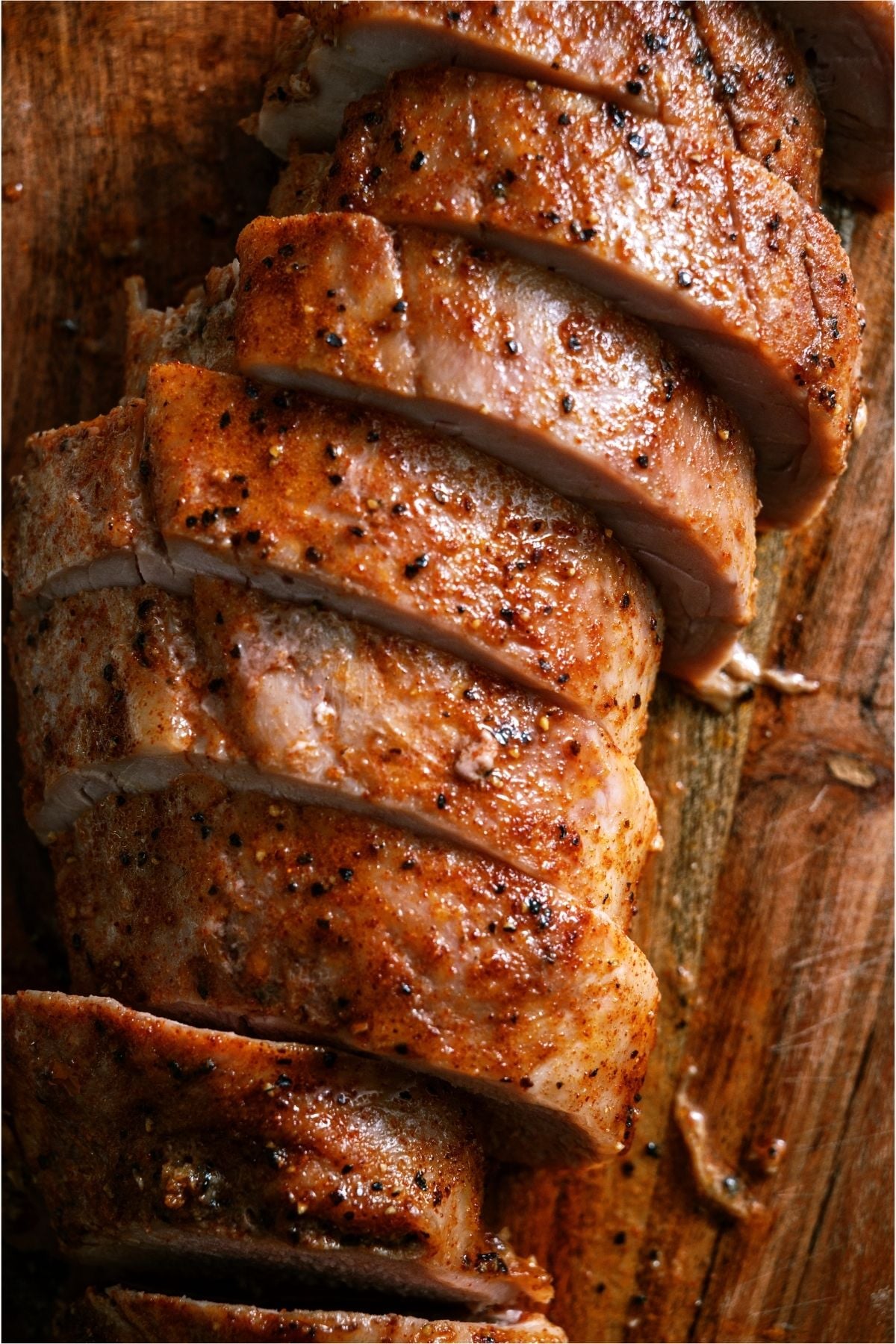 Oven Baked Pork Tenderloin on a cutting board sliced.