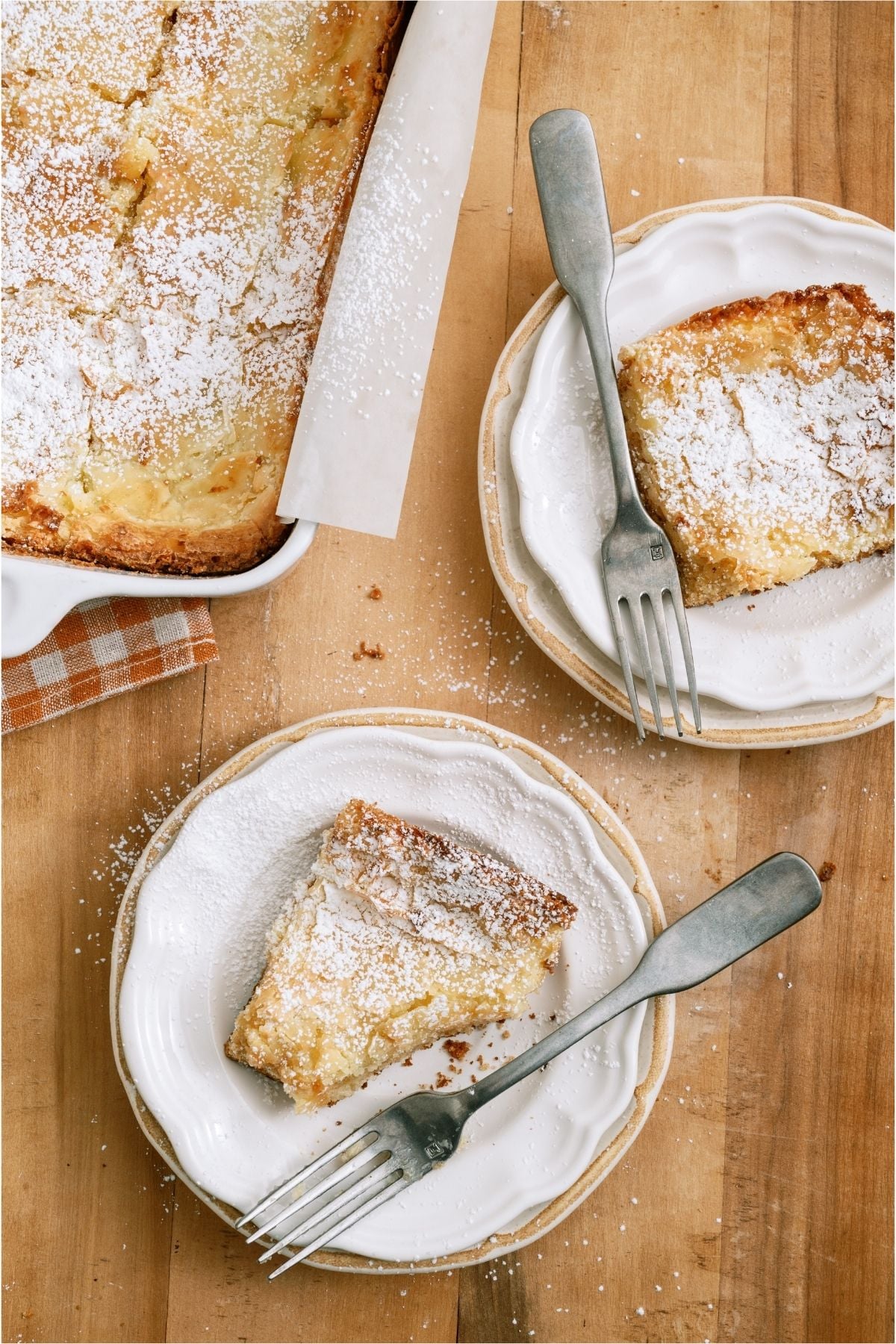 2 plates with slices of Gooey Butter Cake and forks.