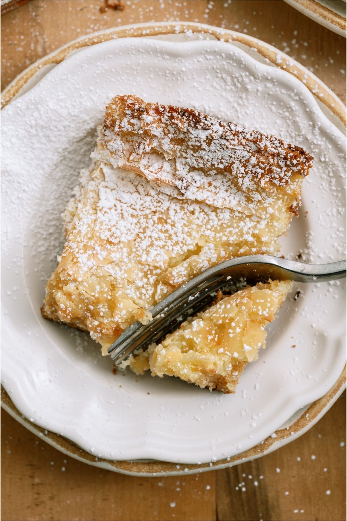 A fork slicing a bite of Gooey Butter Cake.