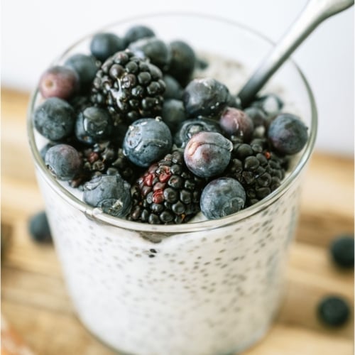 Overnight Chia Pudding in a glass topped with blueberries.