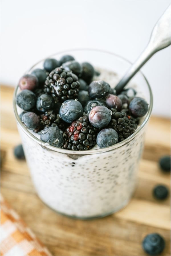 Overnight Chia Pudding in a glass topped with blueberries.