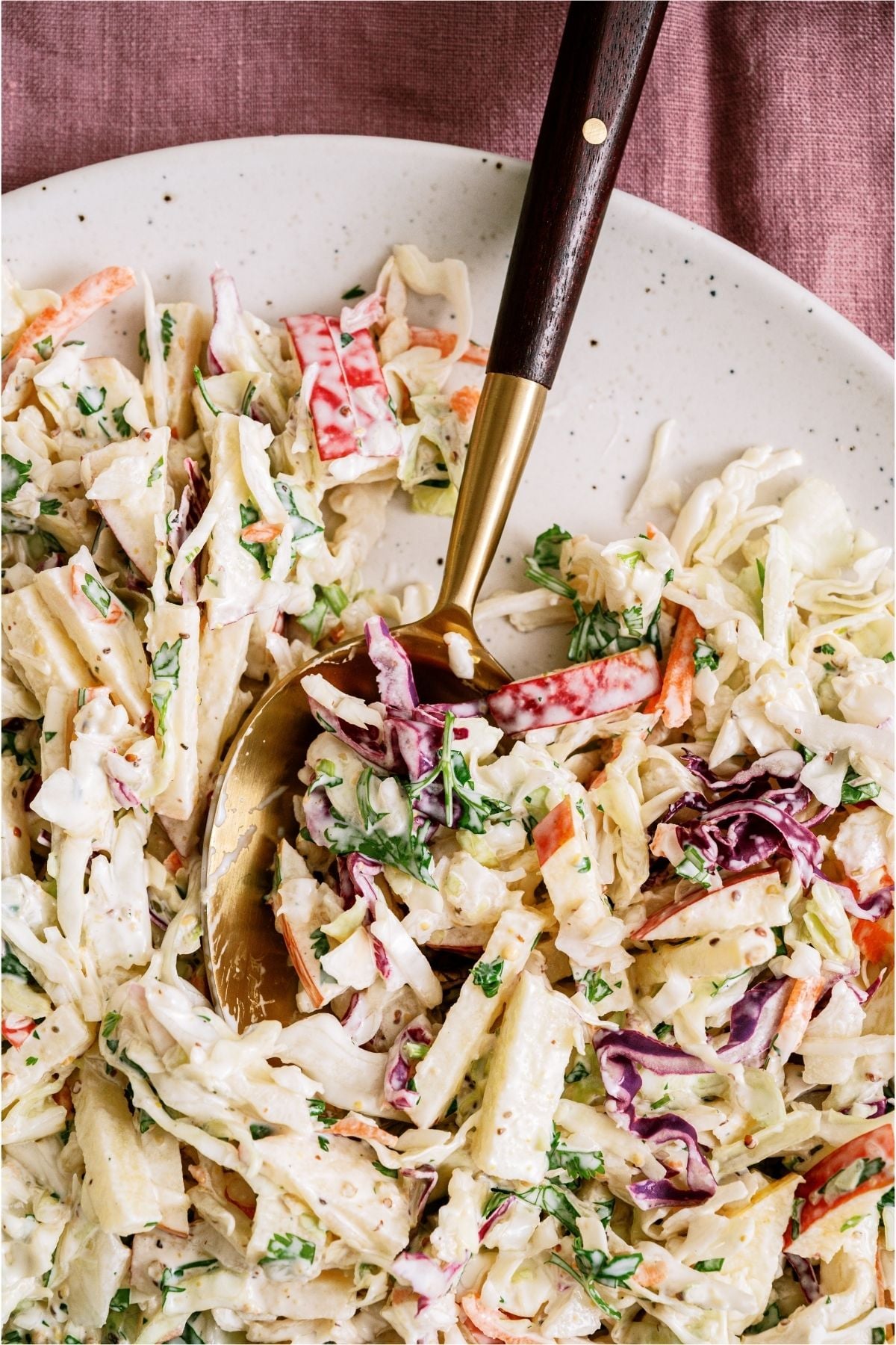 Apple Slaw on a plate with a serving spoon.