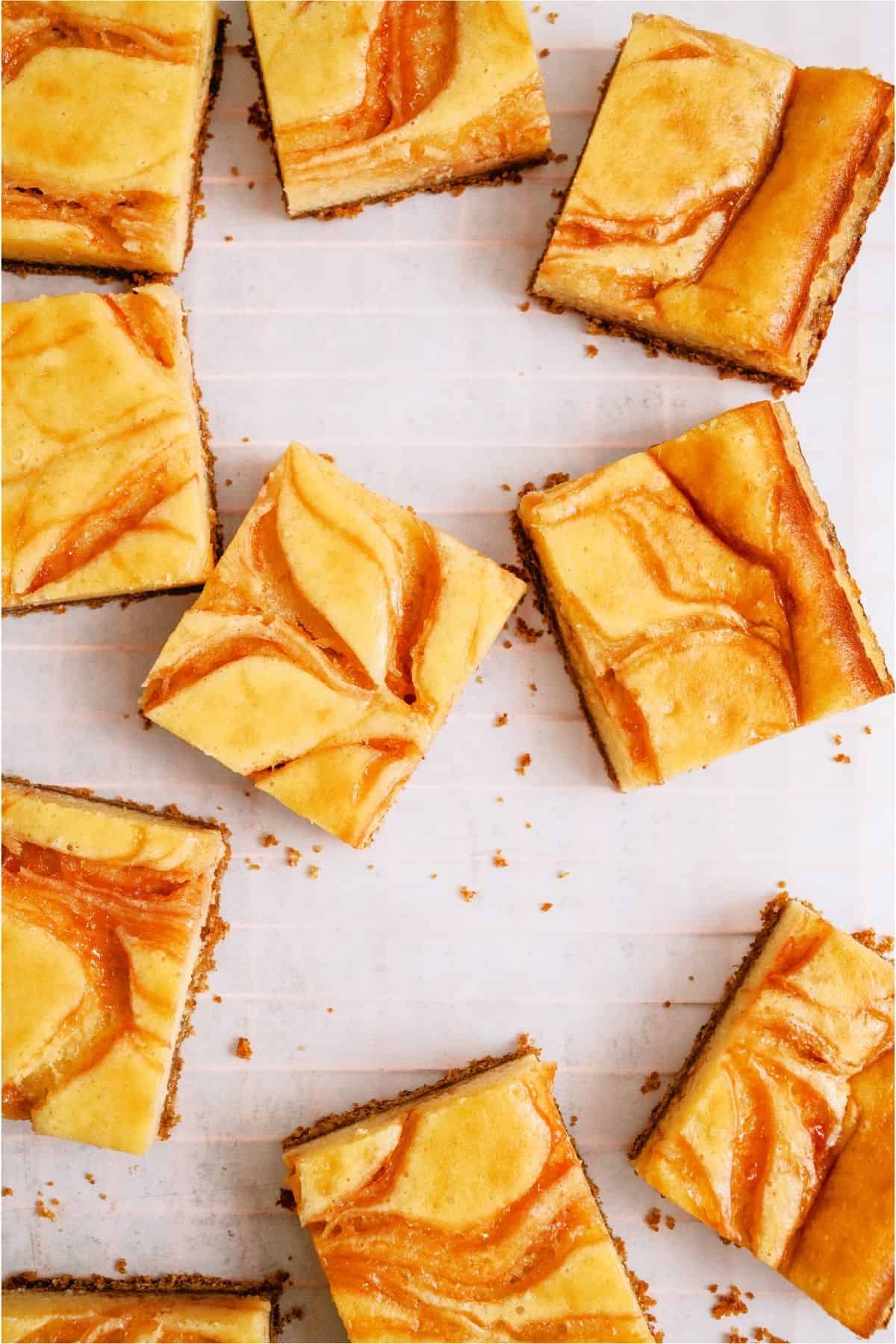 Guava Cheesecake Bars cut into squares and separated on a white background.