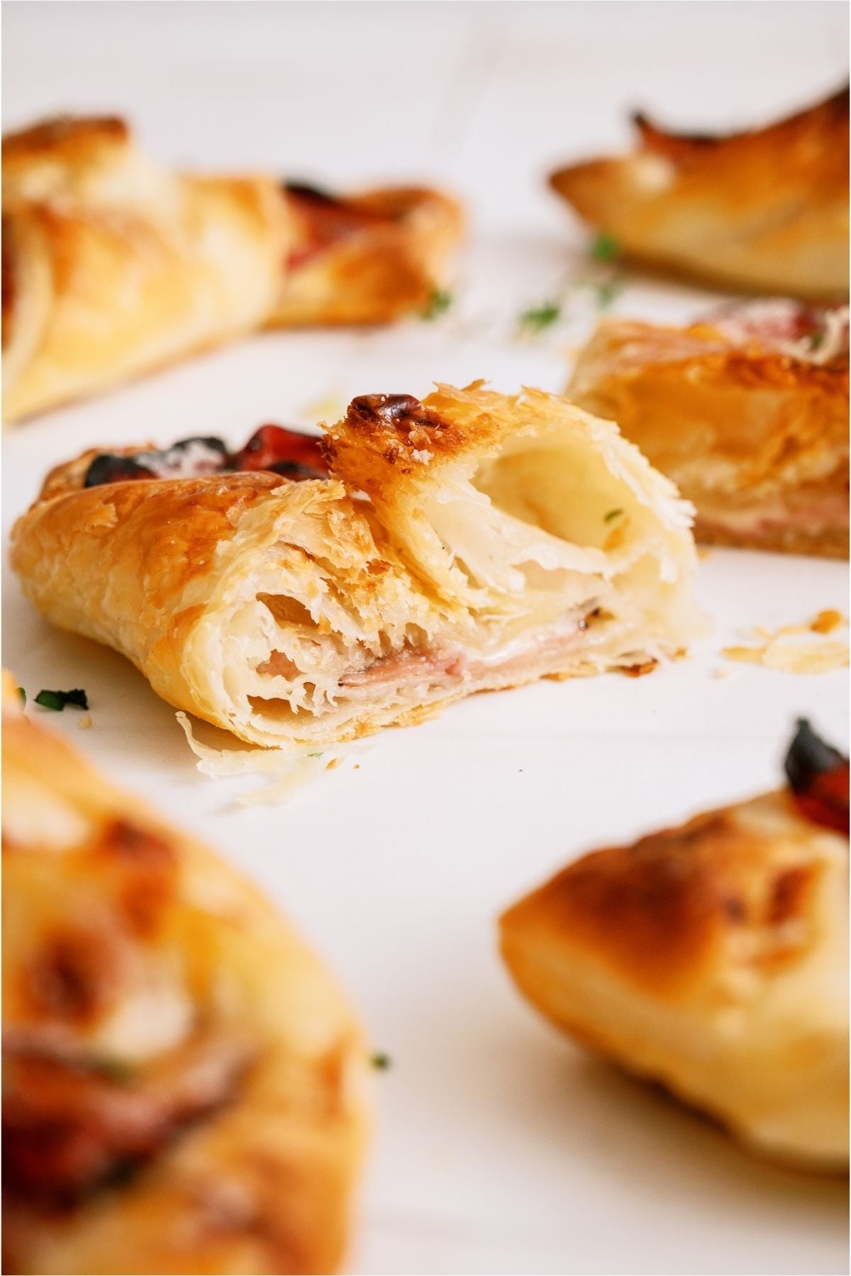 Ham and Swiss Puff Pastries with one cut in half.