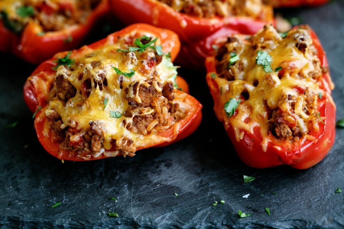 Top view of 2 Air Fryer Stuffed Peppers on a dark background.