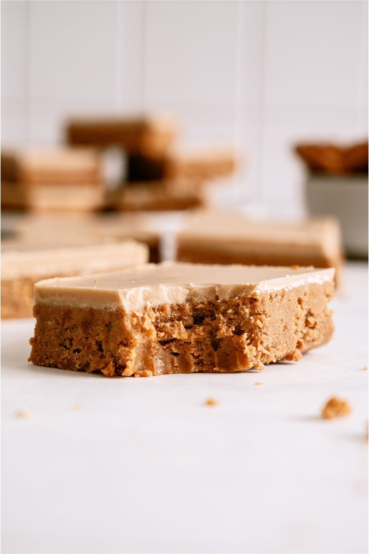 A No Bake Biscoff Bar missing a bite with more No Bake Biscoff Bars in the background.