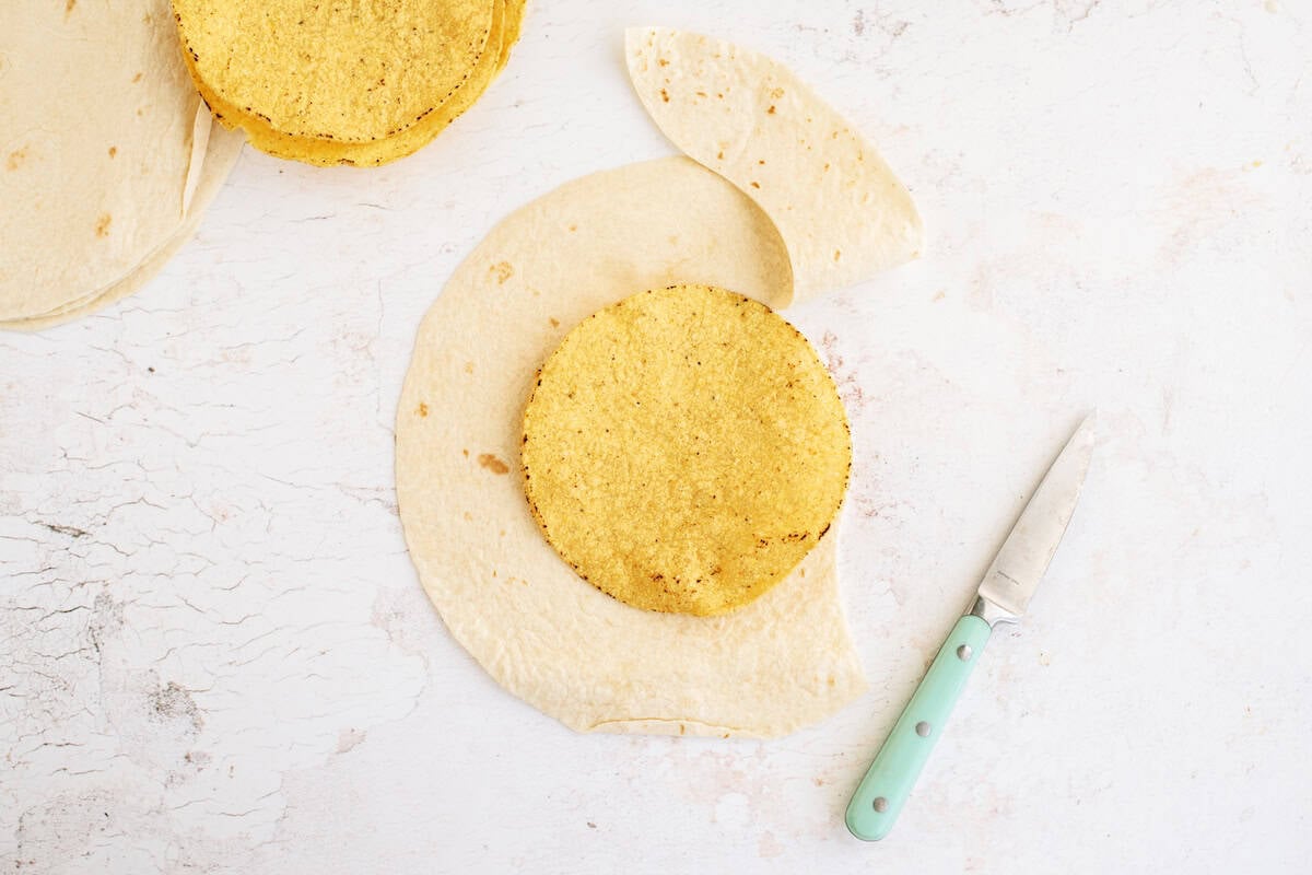 A hard taco shell on top of a soft shell tortilla