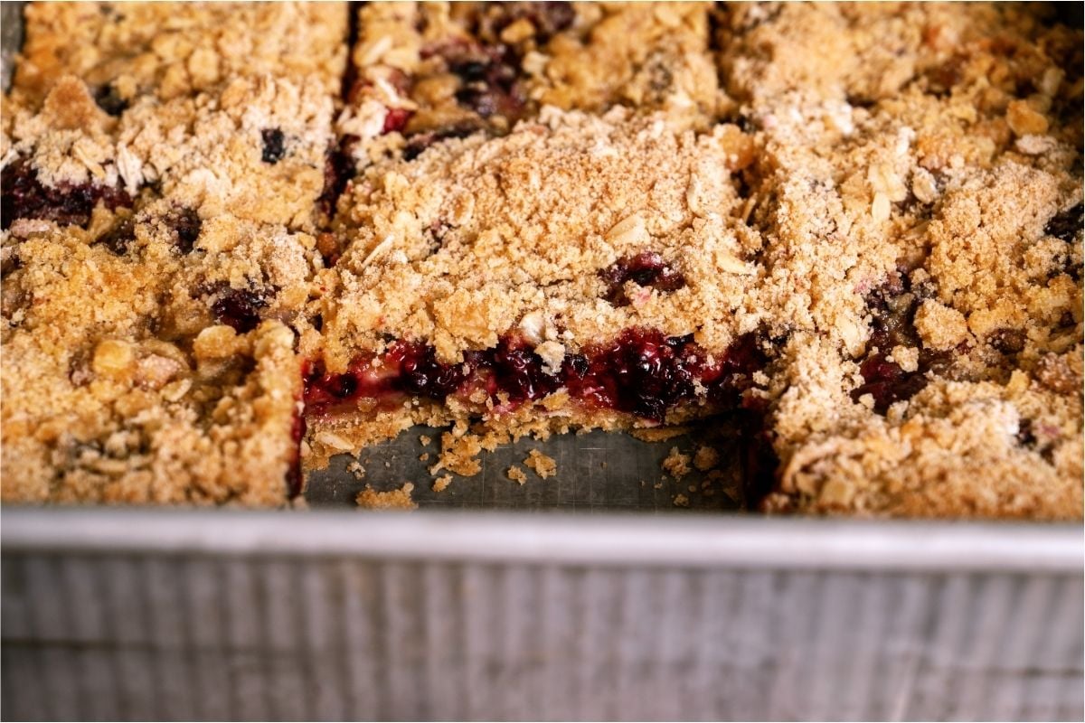 Blackberry Crumble in a pan with a slice missing to show the inside of the crumble.