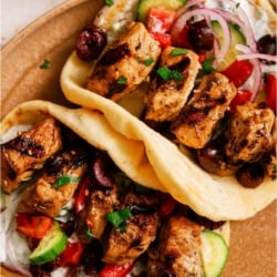 Top view of Pork Souvlaki in pitas on a cutting board.