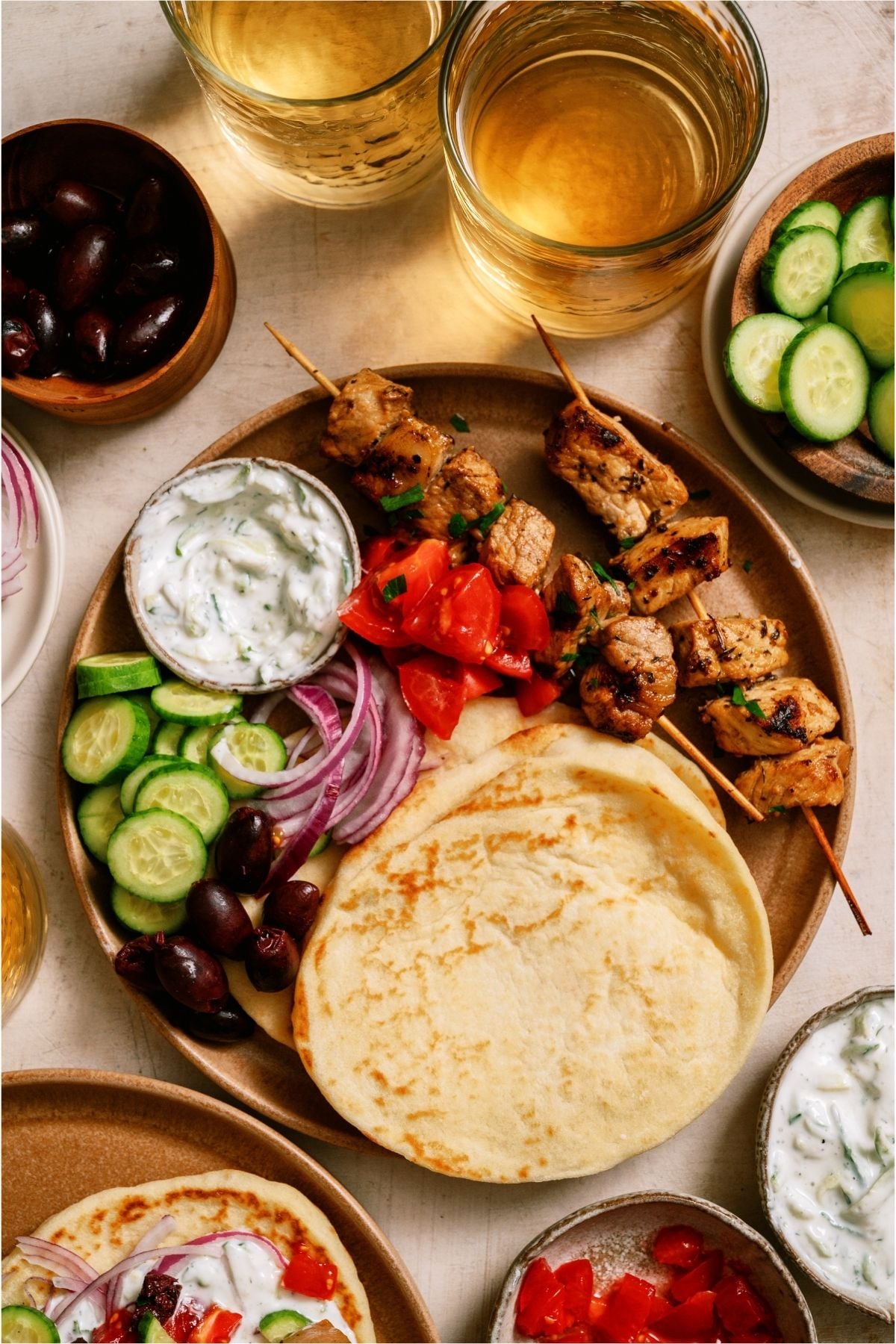 Pork Souvlaki on a serving tray with pita bread and toppings.