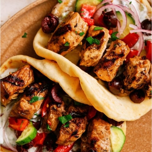 Top view of Pork Souvlaki in pitas on a cutting board.