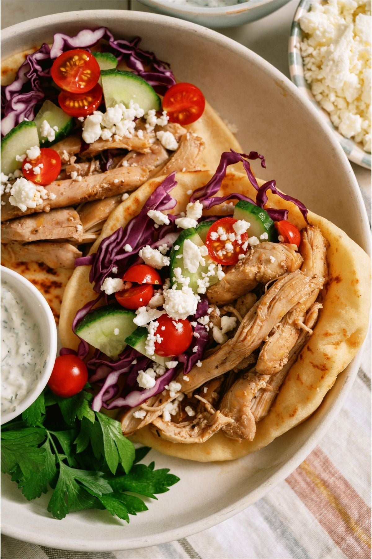 Slow Cooker Chicken Shawarma inside 2 pitas with toppings.