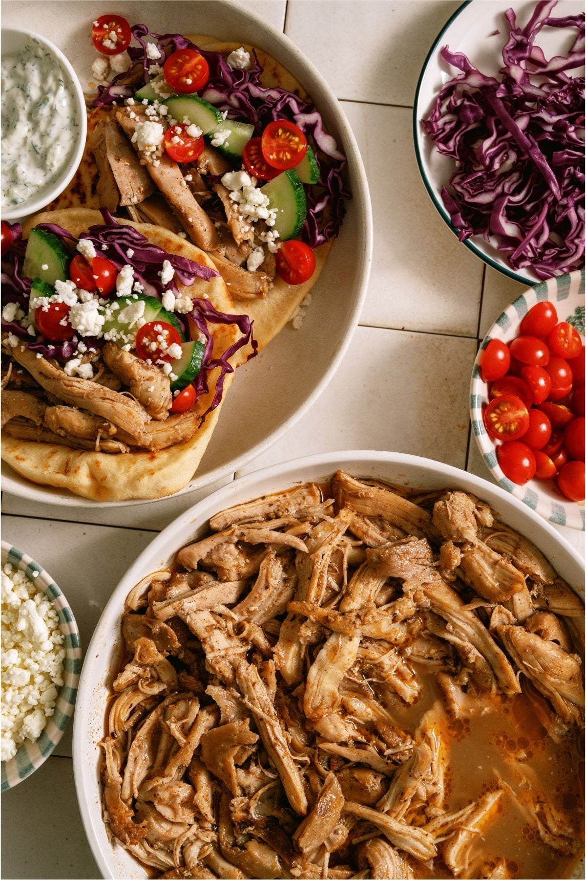 Slow Cooker Chicken Shawarma shedded in a bowl, another bowl with shredded Slow Cooker Chicken Shawarma in pitas with toppings.