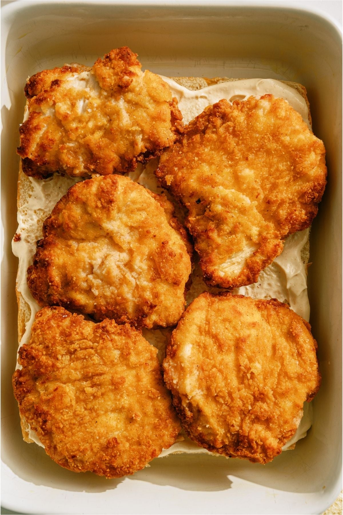 Breaded chicken fillets on top of rolls.