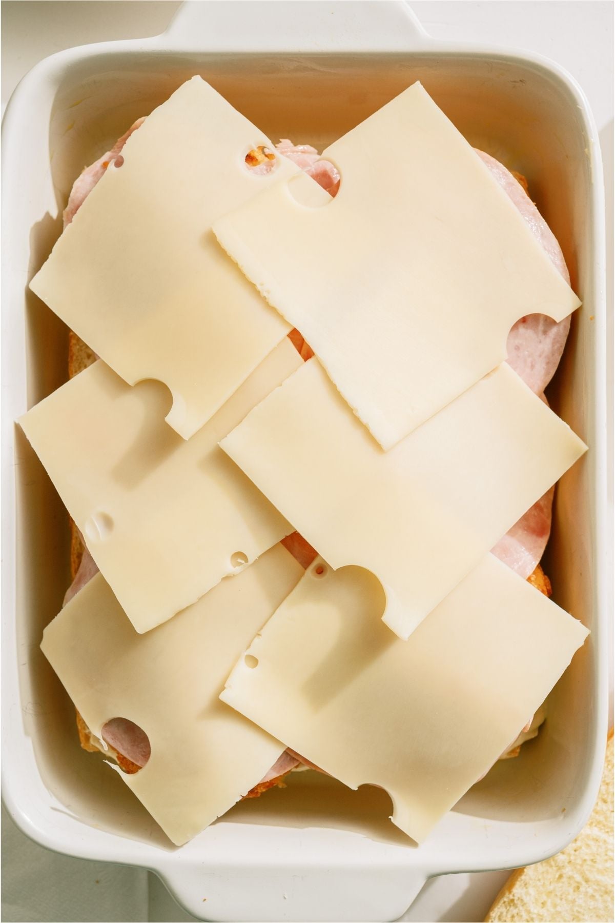 Swiss cheese slices on top of ham.