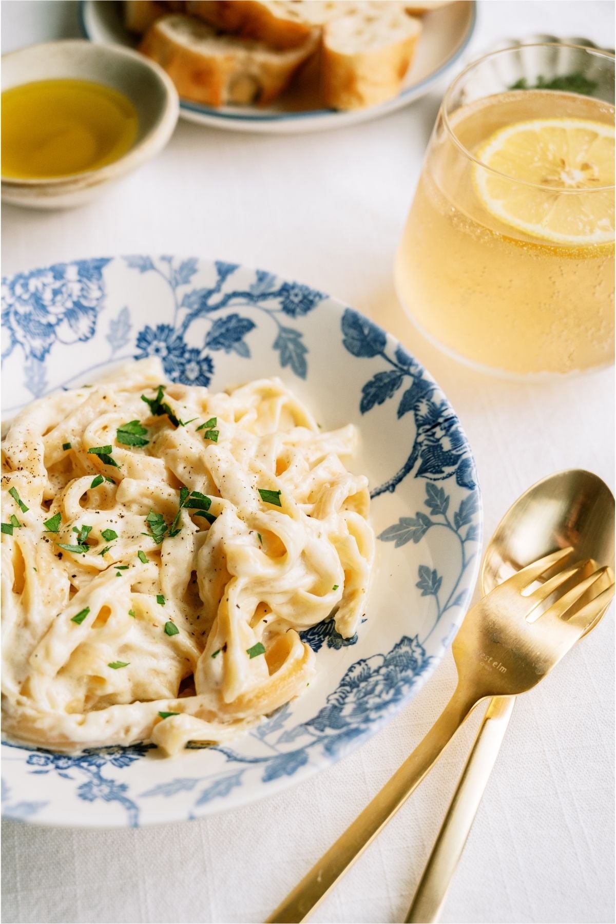 No Fail Fettuccine Alfredo in a bowl with utensils on the side.