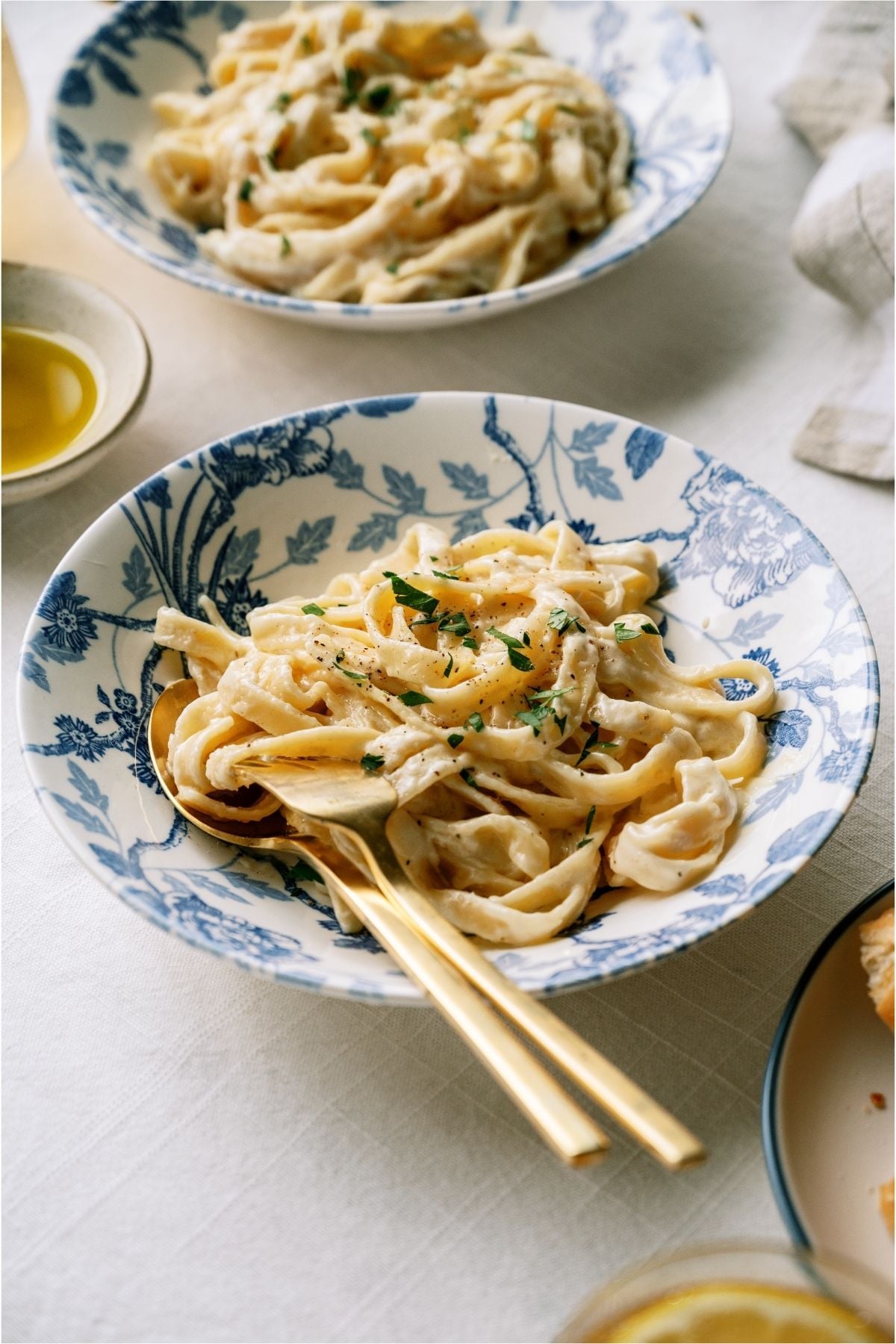 Two bowls of No Fail Fettuccine Alfredo with utensils.