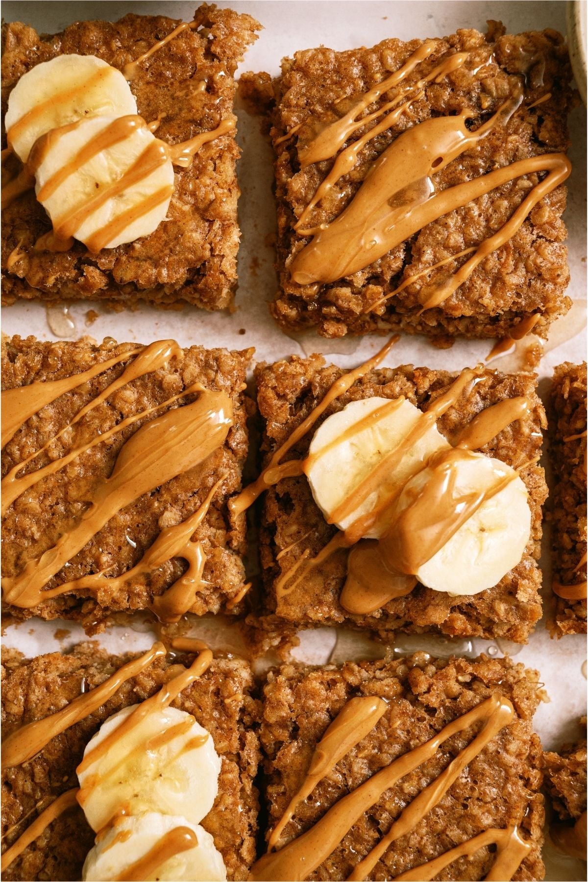 Top view of 6 Peanut Butter Banana Oatmeal Squares topped with bananas and peanutbutter.