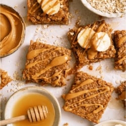 Top view of Peanut Butter Banana Oatmeal Squares wiht a bowl of honey, oats and peanut butter on the side.