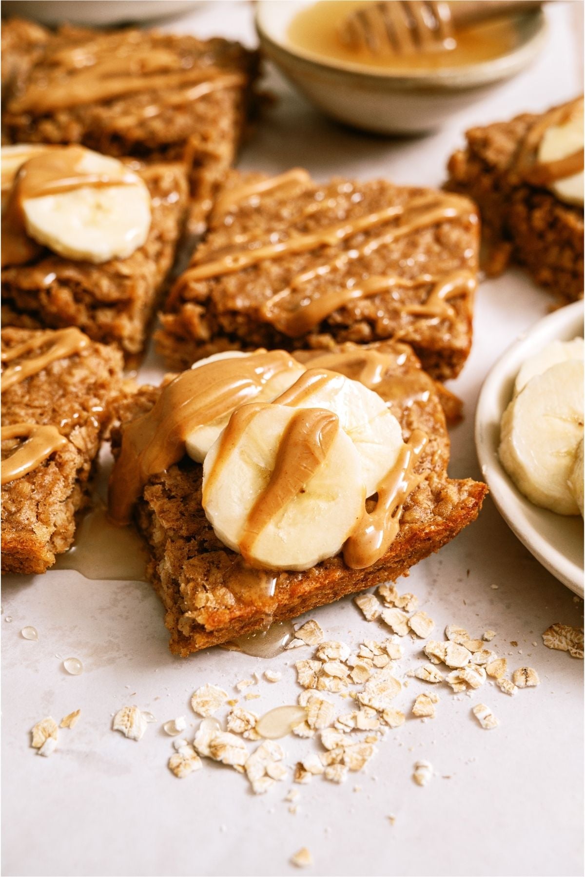 Close up of a Peanut Butter Banana Oatmeal Square topped with bananas and peanut butter.