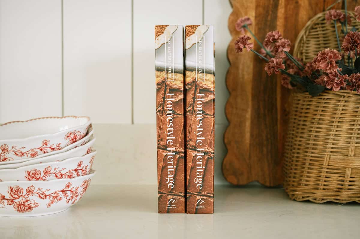 Decorative books on kitchen shelf with floral and rustic accents.