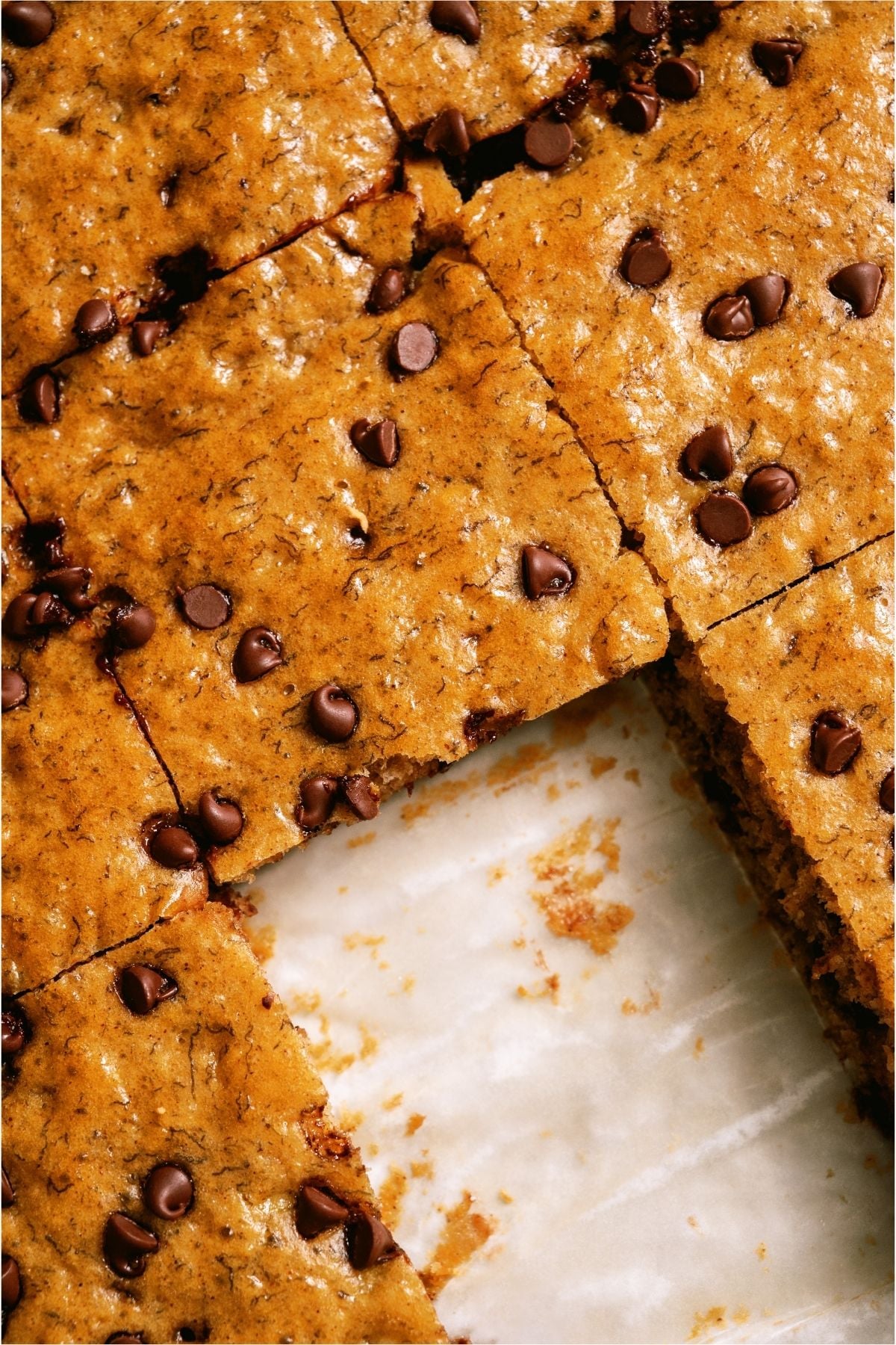 Healthier Banana Sheet Cake cut into squares with one square missing.