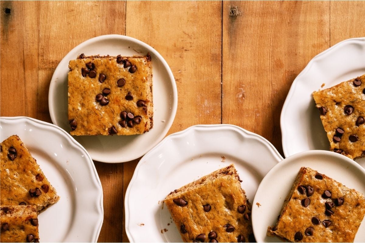 Several slices of Healthier Banana Sheet Cake on a white plates.
