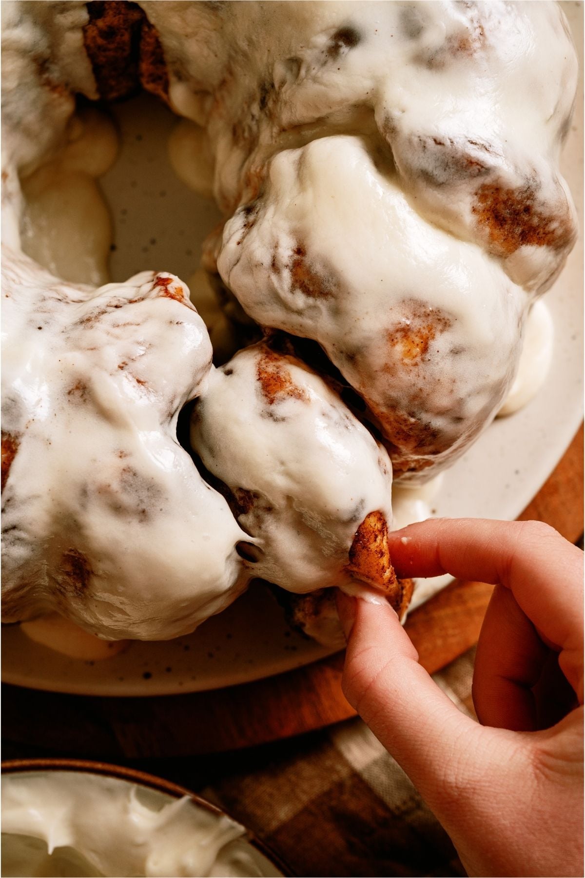 A hand grabbing a slice of Mom’s Cinnamon Pull Apart Bread.