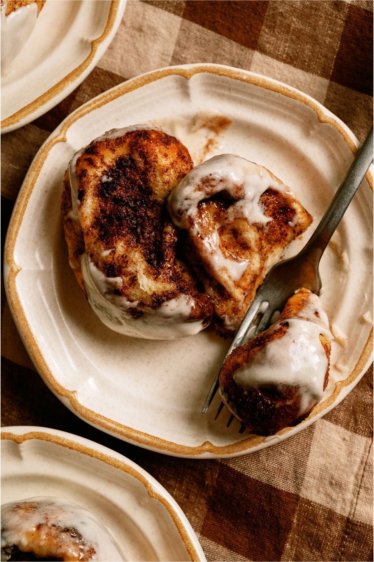 Two slices of Mom’s Cinnamon Pull Apart Bread on a plate with a fork.