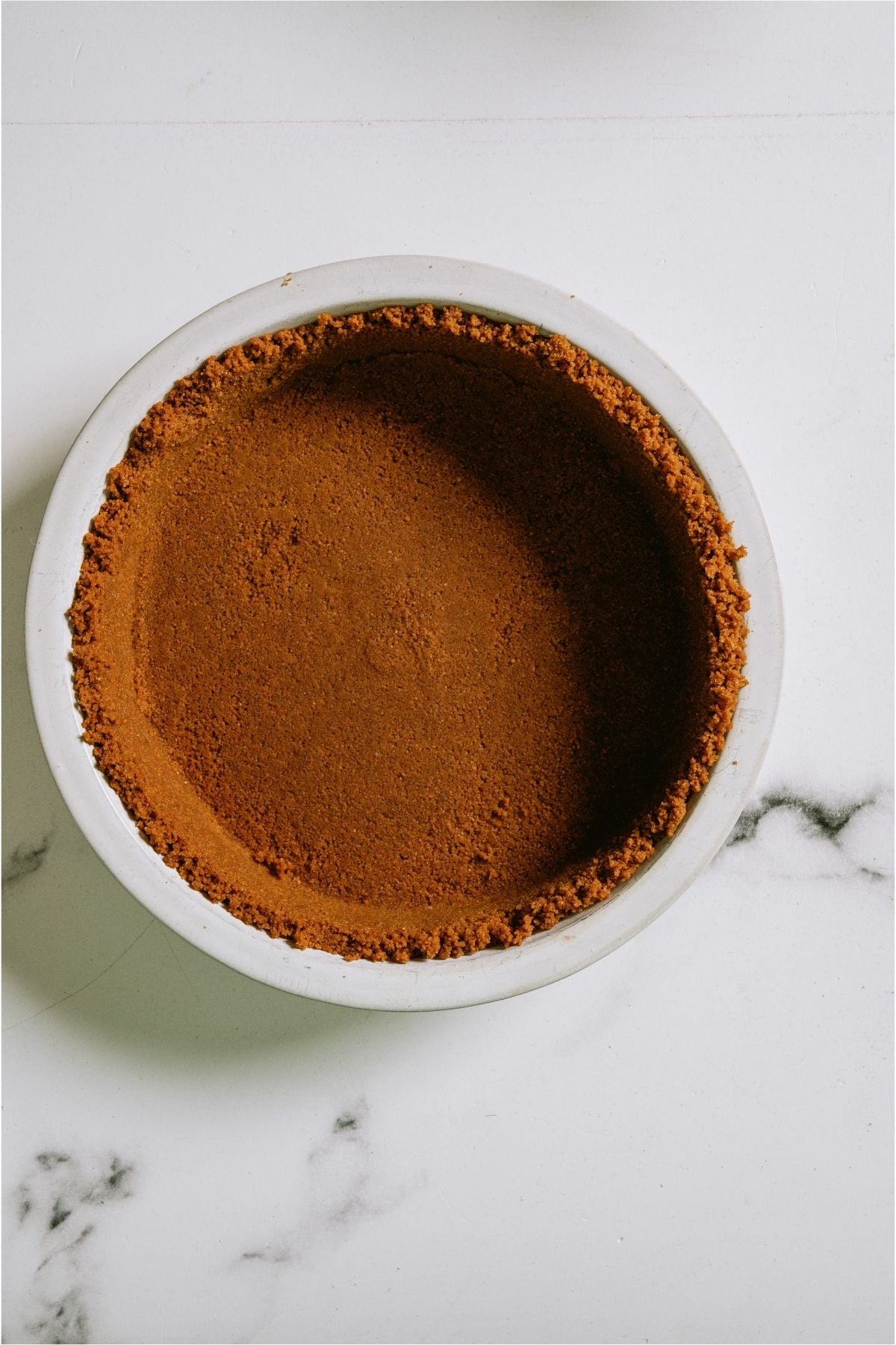 A cookie crust inside a pie dish.